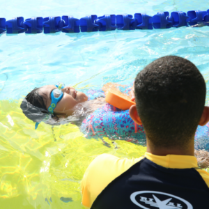 Girl learning how to float on her back and kick